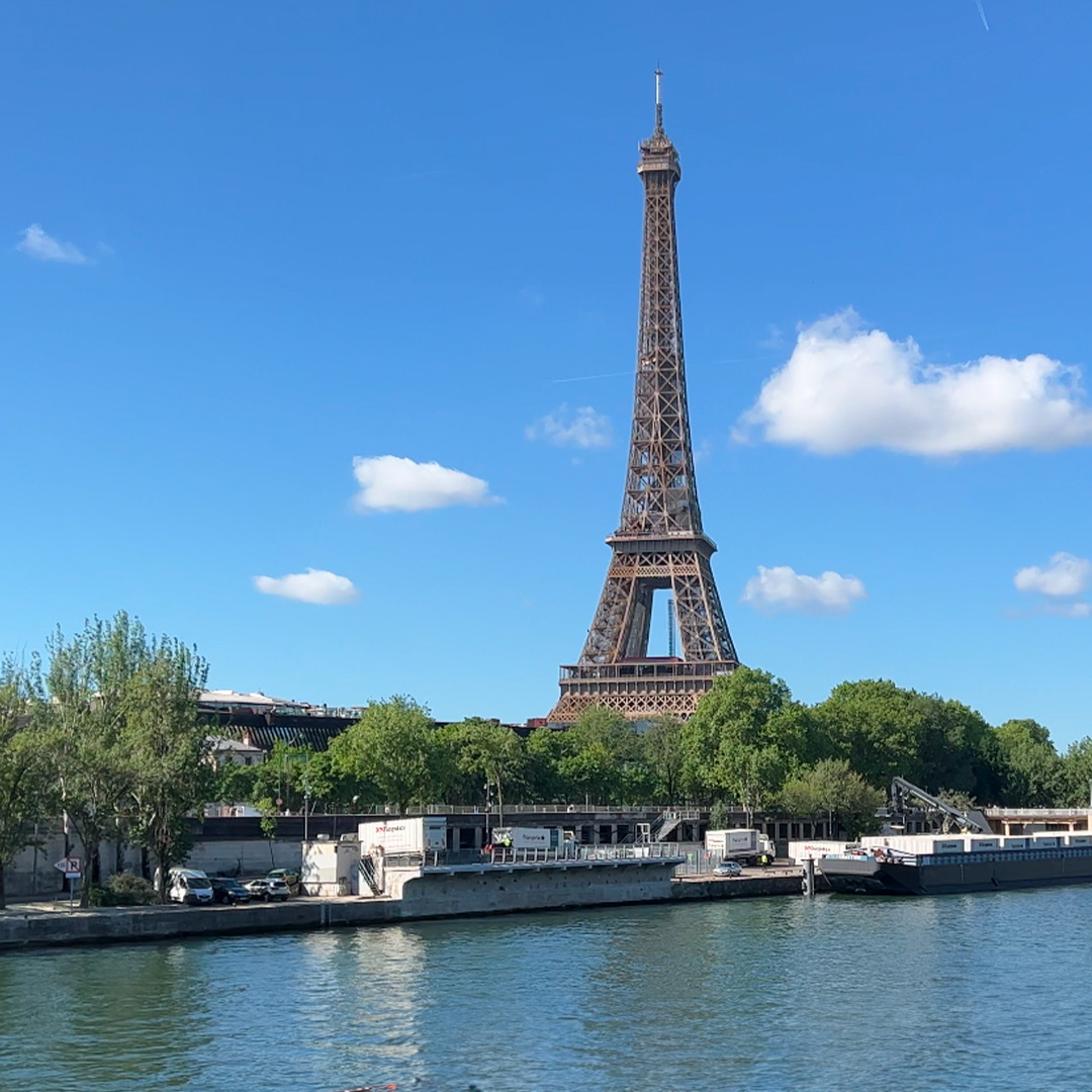 Foto de la Torre Eiffel con un par de nubes y cielo azul