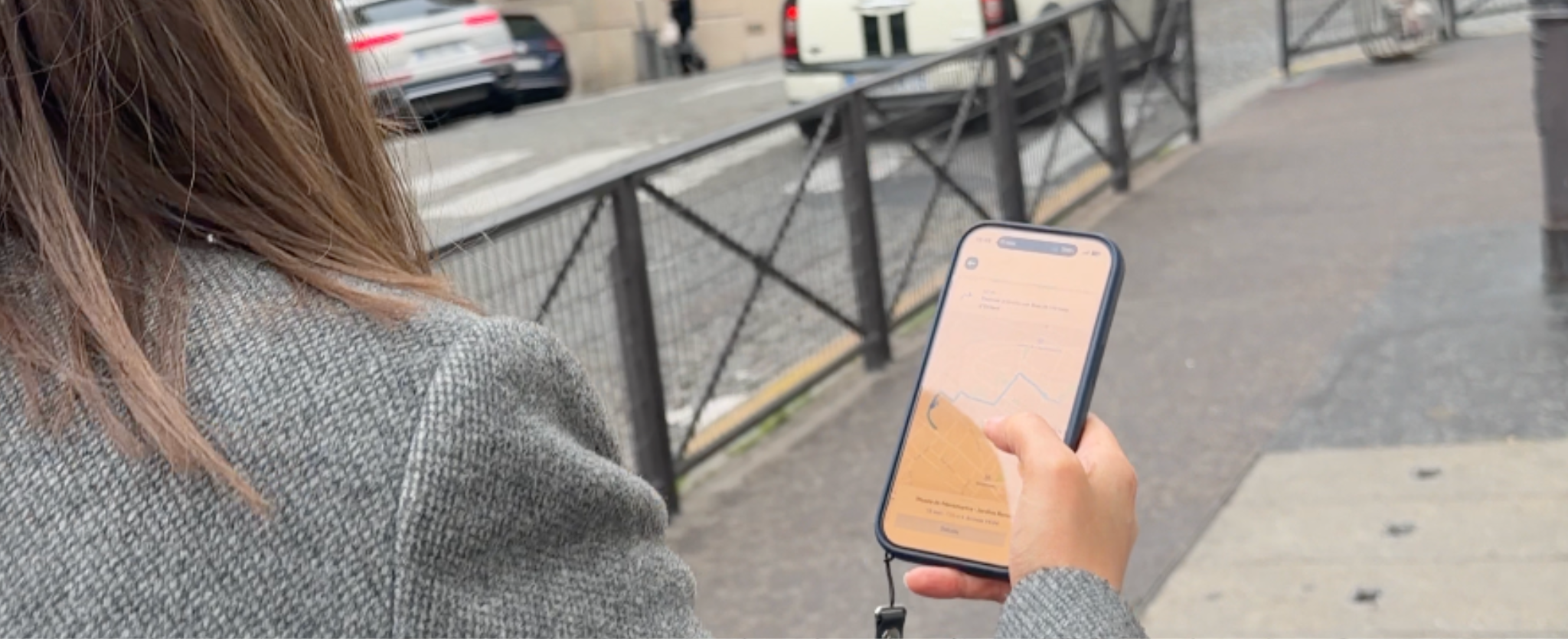 Mujer con celular en mano en París.