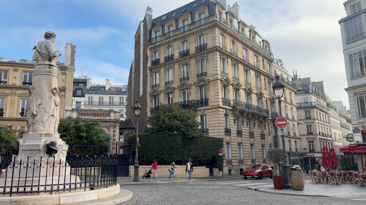 Mujer con celular en mano en París.