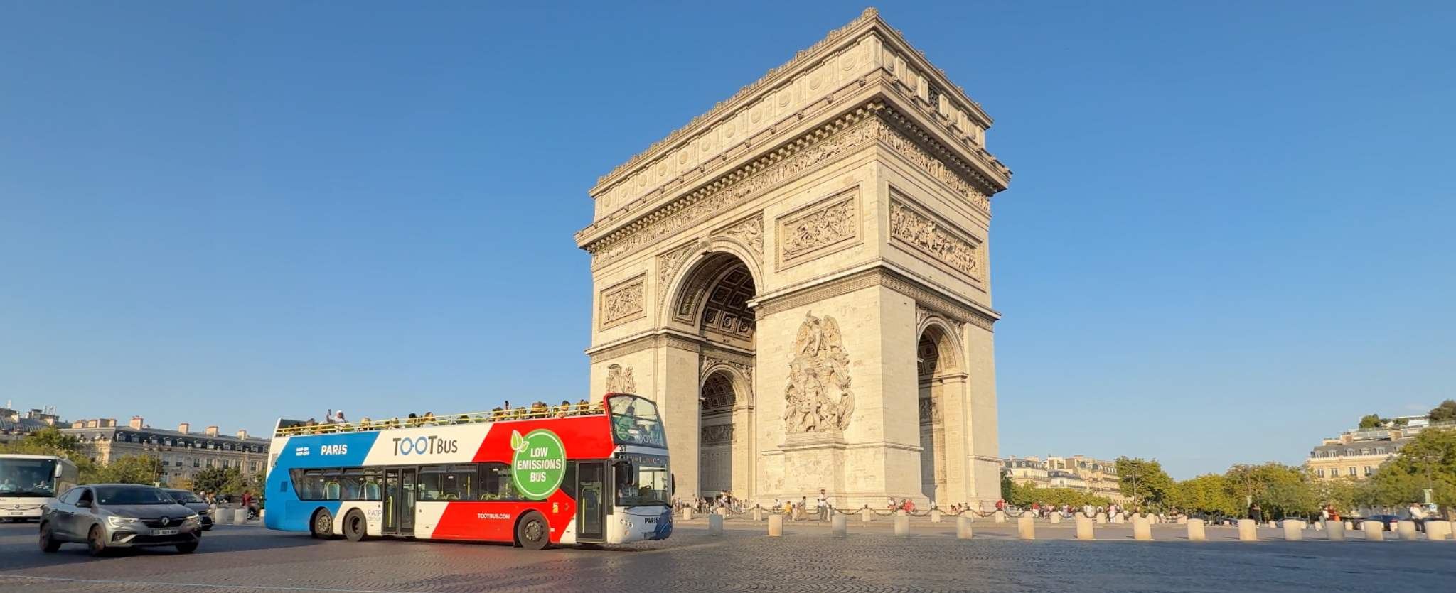 Bus turístico con el arco del triunfo.